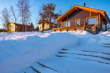 Vacation home. A small house in a cottage village. Snow coffins in front of the cottage. Concept -...