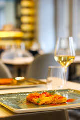 detail of saffron risotto dish with chilli and glass of white wine in a luxury Italian restaurant - 309275160