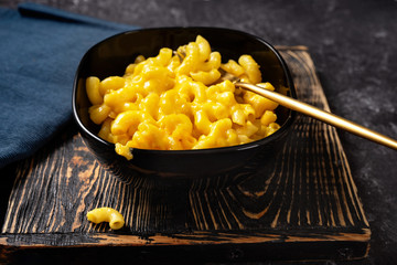 Close up of mac and cheese in black bowl on dark