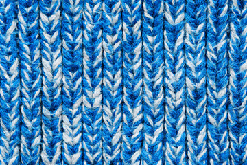 The texture of a knitted sweater. Blue white mottled pattern. Facial surface. Background. Copy space