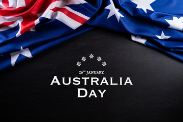 Australia day concept. Australian flag with the text Happy Australia day against a blackboard...