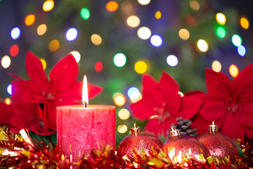 Christmas decoration still life with candle, lights, balls, flowers and ornament.