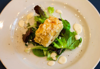 top view of fried roll stuffed with mozzarella with lettuce leafs, cream cheese and pepper, italian restaurant