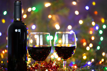 Christmas decoration still life with bottle of wine, glasses of wine, lights, balls and ornament.