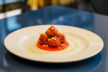 plate of meatballs with fresh sauce and pine nuts and a little olive oil - 309277170