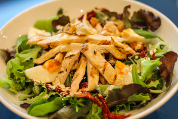 detail of plate with fresh salad, chicken, eggs and dry tomato