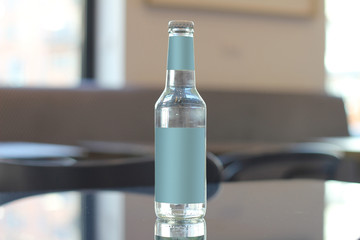 water bottle with blank labels on reflective table and restaurant lights