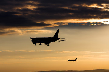 Fototapeta na wymiar passenger airplanes landing in the evening sun