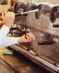italian barista uses a traditional coffee machine to prepare espresso and cappuccino - 309277912