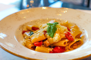 plate with handmade paccheri pasta and sautéed aubergines, citrus-flavored confit cherry tomatoes and spotted red in fine Italian restaurant - 309277914