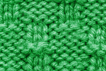 The texture of a knitted sweater. Green pattern. Facial surface. Background. Copy space
