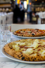 table for two in an Italian pizzeria with two hot pizzas ready to eat