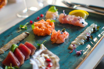 haute cuisine dish of raw fish with oyster, cicada, ricciola, scampi, prawns, tuna and salmon in a fine Italian restaurant