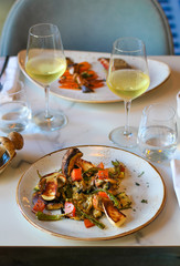 table for two in a luxury Italian restaurant, dishes with roasted eggplant, candied pumpkin, marinated scapece courgette, fried fry of Penta di Frisciano, sautéed porcini mushrooms and sage
