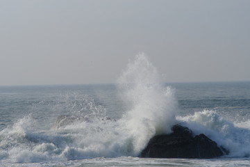 Fototapeta premium Schizzi di aqua tra le rocce e il porto