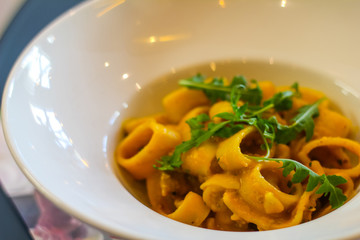 saffron-flavored paccheri with rocket and pepper in an Italian restaurant