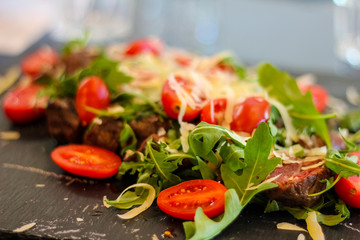 Freshly scalded rump heart accompanied by rocket, cherry tomatoes and provola flakes in an Italian restaurant