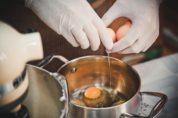 Obraz na płótnie Canvas the cooks hands break the egg over the pan