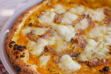 detail of pumpkin cream pizza, bacon, grated provola and grana cheese and a drizzle of extra virgin olive oil.