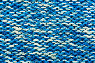 The texture of a knitted sweater. Blue white mottled pattern. Facial surface. Background. Copy space