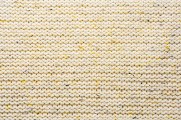 The texture of a knitted sweater. Beige pattern. Inside. Background. Copy space