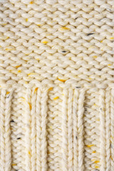 The texture of a knitted sweater. Beige pattern. Inside. Background. Copy space