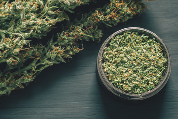 marijuana with trichomes Macro of and crushed weed in a grinder for chopping a canapis on a black...