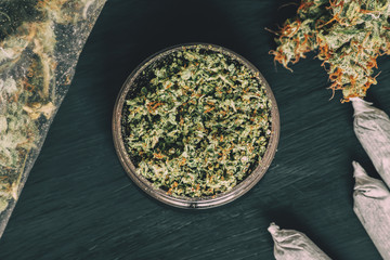 rolled joint in a grinder Macro of marijuana with trichomes and crushed weed and for chopping a...