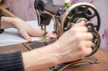 Woman working on old sewing machine