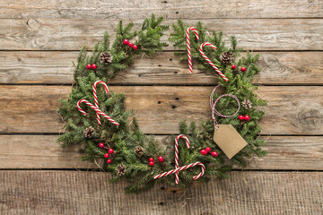 Christmas wreath with decorations on vintage wooden background