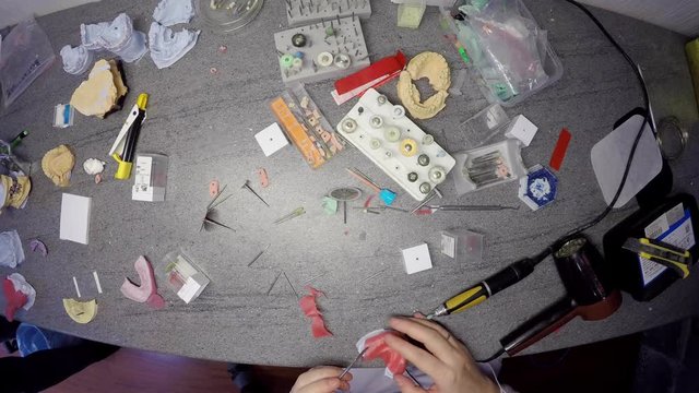 Timelapse from above of dental technician table, he is making a model of jaws