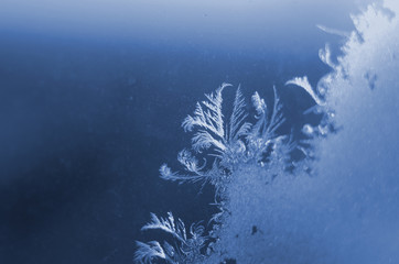 Macro of ice on frozen window close up. Classic Blue color. Color of the year 2020. Trendy color.