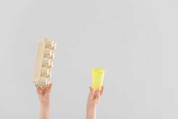 Hands with garbage on light background. Concept of recycling