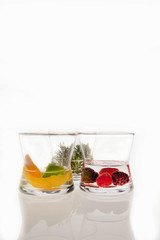 Three clear glasses with fruit on white background