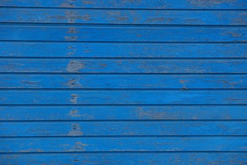 blue wooden texture of thin frayed boards in the wall of the fence