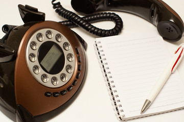 phone handset and notebook on a white background