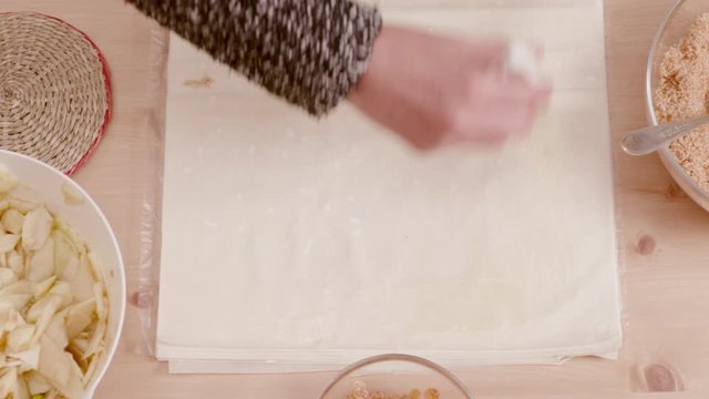 Woman's Hand Brushing Filo Pastry With Melted Butter Shot From Above