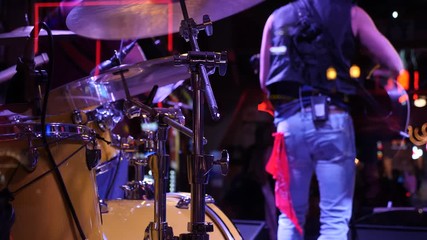 Band plays country music in honky tonk bar. Back view. Drummer and guitarist. - Powered by Adobe