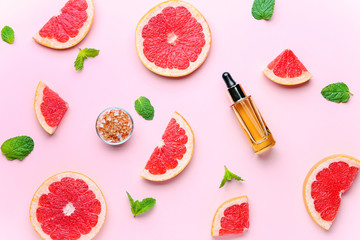 Composition with grapefruit essential oil on color background