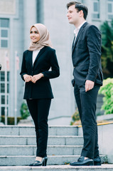 Couple of young executive people in formalwear standing with confident face expression