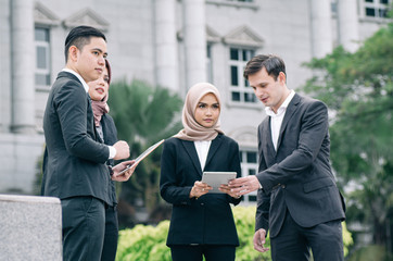 Group of young executive people in formalwear discussing something and gesturing