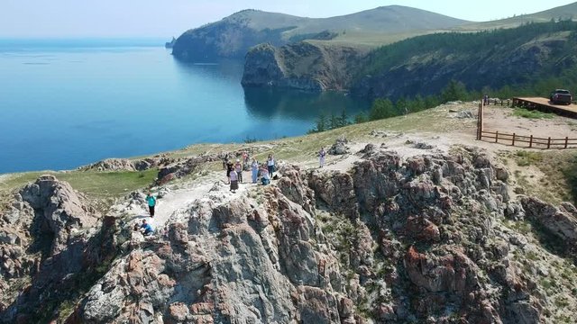 The Cape of the island Olkhon, lake Baikal. The Nature Of Russia. Aerial video shot. Drone over the rocks and tourists taking photo.
