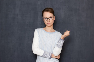 Portrait of serious focused girl with glasses, waiting the results