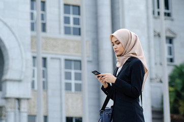 Portrait of young Office Woman Texting to Someone on her Mobile Phone with Happy Facial Expression.