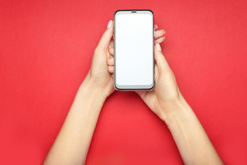 Female hands with modern mobile phone on color background