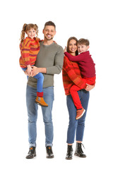 Happy family in winter clothes on white background