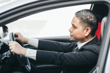 side view young businessman sitting in his car and drive to work place