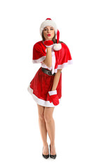Beautiful young woman in Santa costume blowing kiss on white background