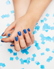 Female hand with trendy manicure in blue color. Color of the year 2020.