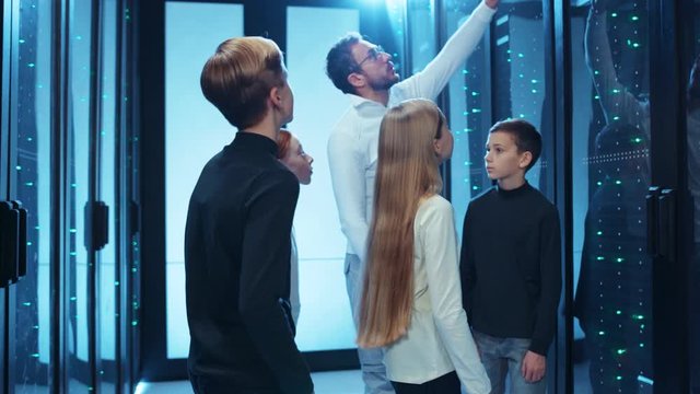 IT professional leads exciting tour for kids in database cyber security. Cute team of school children learning technology internet science in data center.